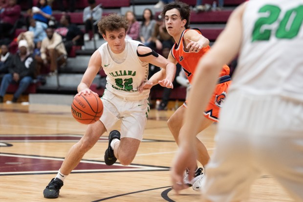 Illiana Christian guard Isaac Sherwood drives toward the basket past North Newton guard Adan Castleberry during the first round of the Class 2A Bowman Sectional on Wednesday, February 28, 2024. (Kyle Telechan/for the Post-Tribune)