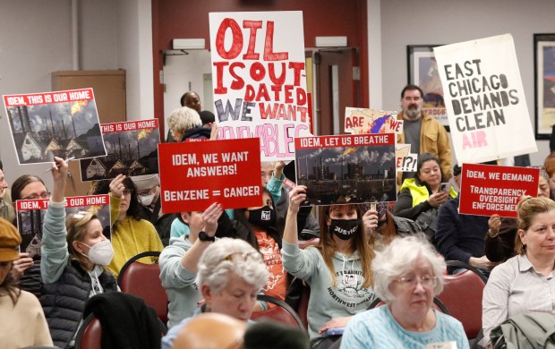 A group of residents hold up protest signs during a public meeting to discuss air permitting for BP Products of North America. East Chicago school officials cancelled a planned Indiana Department of Environmental Management (IDEM) public meeting more than a week ago, a second one was held at Calumet College of St. Joseph in Whiting on Thursday, February 22, 2024. (John Smierciak/Post Tribune)