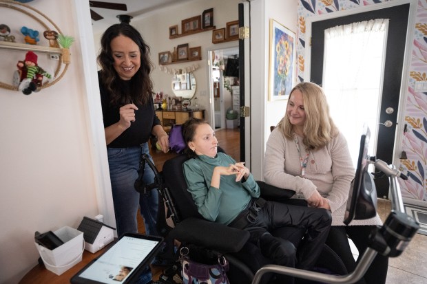 Crown Point resident Mimi Burke, on left, and her daughter Sophia, who has Rett Syndrome, work with Crown Point Schools speech language pathologist Adrian Herrenbruck during a speech therapy session on Thursday, January 25, 2024. (Kyle Telechan for the Post-Tribune)