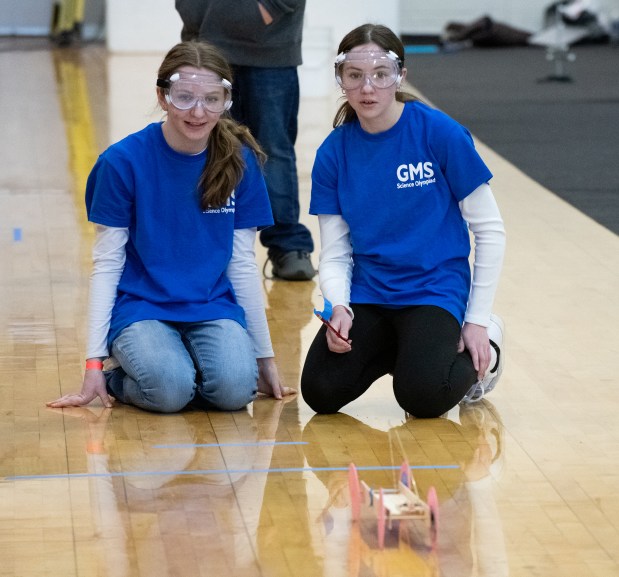 Grimmer Middle School seventh-graders Jenna Smith, left, and Katie Pepkowski watch as their car rolls down the track during competition in the Wheeled Vehicle category at the Science Olympiad Regional Tournament at IU Northwest in Gary, Indiana Saturday February 17, 2024. (Andy Lavalley for the Post-Tribune