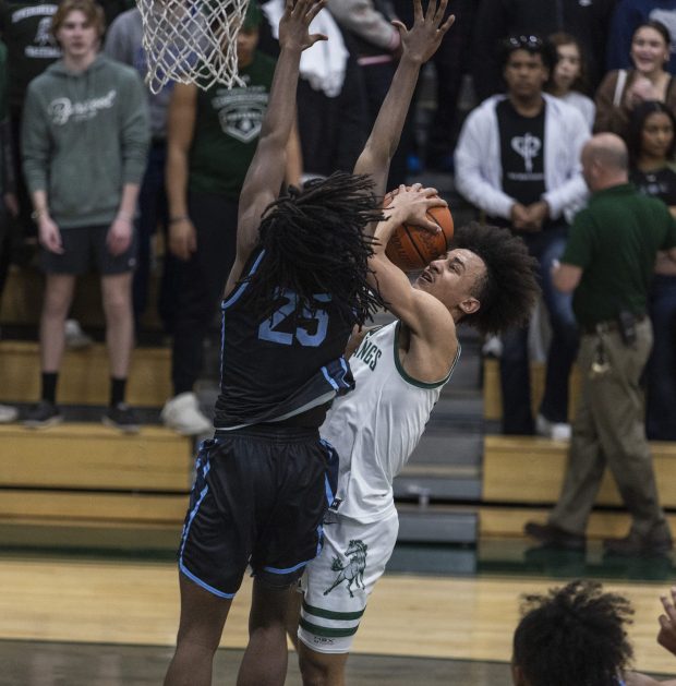 Hillcrest's Jaylen West (25) tries to block Evergreen Park's Tre Dowdell during the Class 3A Evergreen Park Regional final in Evergreen Park on Friday, Feb. 23, 2024. (Vincent D. Johnson / Daily Southtown)