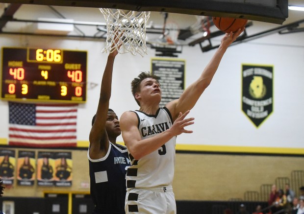 Mount Carmel's Grant Best (3) lays in a basket against Hyde Park's Marquise Merritt (2) during the Class 3A Hinsdale South Sectional semifinals Tuesday, February 27, 2024 in Darien, IL. (Steve Johnston/Daily Southtown)