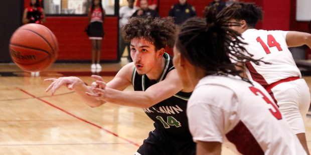 Oak Lawn's Sean Ryan (14) passes away from Eisenhower's Ayipey Salinas (3) during a basketball game in Blue Island on Tuesday February 13, 2024. (John Smierciak / Daily Southtown)