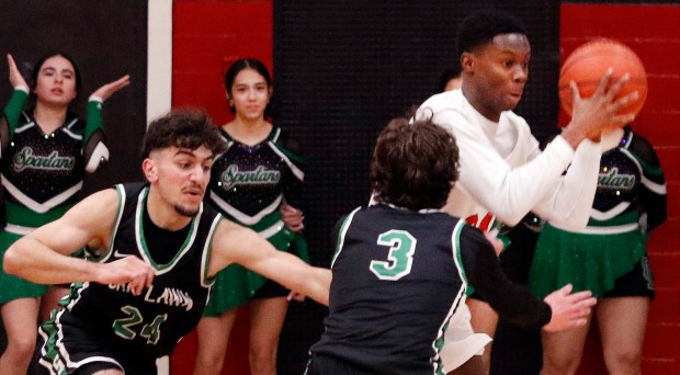 Oak Lawn's Omar Saleh (left) and Jack Dempsey (center) go after a loose ball as Eisenhower's Ola Solomon (right) comes up with it during a basketball game in Blue Island on Tuesday February 13, 2024. (John Smierciak / Daily Southtown)