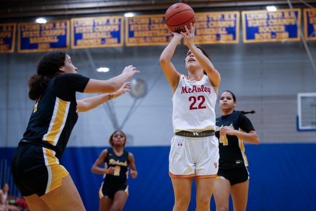 Maeve Egan (22) from Mother McAuley puts up a shot over Iyana Crosby (1) from Richards during the first quarter of their IHSA Class 4A Girls Basketball Regional semi-final at Lyons Township High School on Monday, February 12, 2024 in LaGrange, Illinois. The Mighty Macs defeated the Bulldogs 58-30 to advance to their regional final. ( John Konstantaras-Daily Southtown ) | 3156497_STA-L-GBK-LYONS-REG-0214