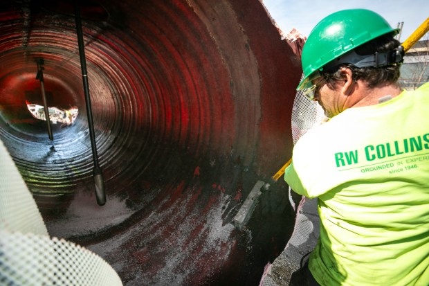 A worker spreads a chemical absorption compound Monday inside an excavated diesel-fuel storage tank at the former Tinley Park Mental Health Center. (Vincent D. Johnson / Daily Southtown)