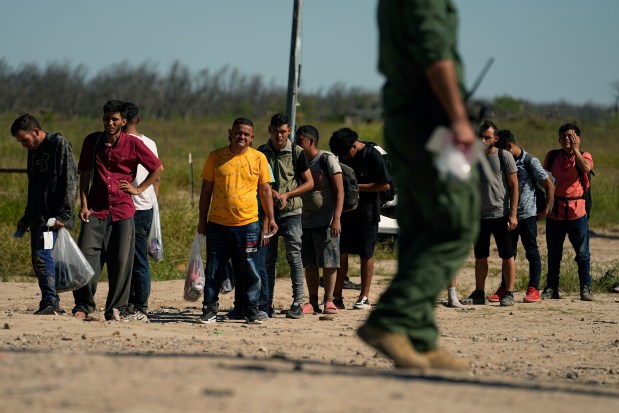 Migrants wait to be processed by the U.S. Customs and Border Patrol after they crossed the Rio Grande and entered the U.S. from Mexico, Thursday, Oct. 19, 2023, in Eagle Pass, Texas. Starting in March, Texas will give police even broader power to arrest migrants while also allowing local judges to order them out of the U.S. under a new law signed by Republican Gov. Greg Abbott.