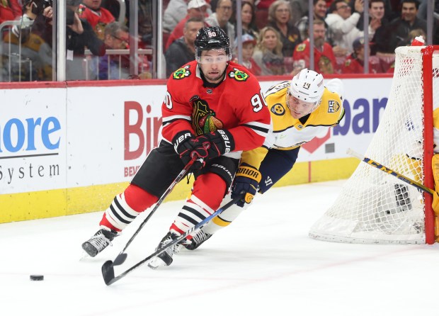 Chicago Blackhawks center Tyler Johnson (90) and Nashville Predators center Gustav Nyquist (14) skate to the puck in the first period at the United Center on Dec. 5, 2023.