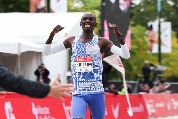 Kelvin Kiptum celebrates his Chicago Marathon world record victory, 2:00:35, in Chicago's Grant Park on Oct. 8, 2023.