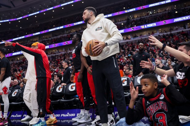 Injured Bulls guard Zach LaVine grabs a ball after it went out of bounds during the third quarter on Dec. 26, 2023, at the United Center.