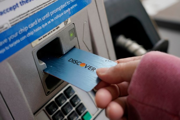 A Discover card is used to pay for gasoline at a Sam's Club in Madison, Miss., July 1, 2021. Capital One Financial is buying Discover Financial Services for $35 billion, in a deal that would bring together two of the nation's biggest lenders and credit card issuers. (Rogelio V. Solis/AP)