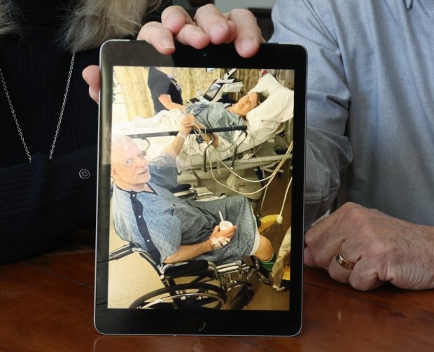 Carol and Jon McCabe sit for a portrait with a picture from their May 2022 transplant surgery, on Saturday, Feb. 17, 2024, in Clarendon Hills. (John J. Kim/Chicago Tribune)