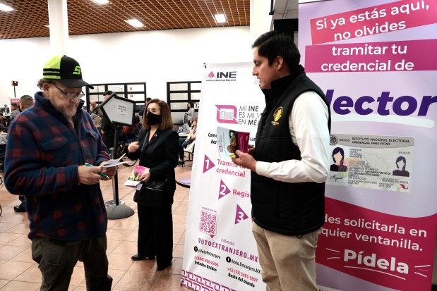 Luis Cedeno, right, with the Community Affairs Department at the Consulate General of Mexico in Chicago, provides information on Feb. 13, 2024, to Chicago resident and Mexican citizen Salvador Hernandez, 64, about how to vote in person at the consulate for the Mexican presidential elections in June. (Antonio Perez/Chicago Tribune)