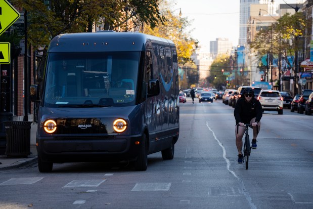 A cyclist veers into Lincoln Avenue to avoid a delivery truck parked in the bike lane in the Lincoln Park neighborhood on Nov. 14, 2023. (E. Jason Wambsgans/Chicago Tribune)