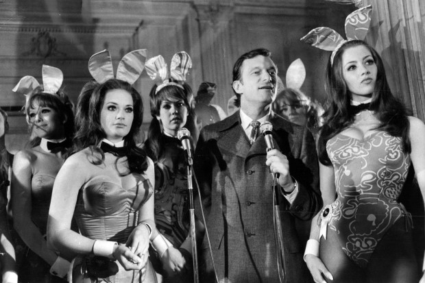 Pocketing his pipe, Hugh Hefner talks at an open house reception for girls from the area who want to be bunnies at his Playboy Mansion on North State Parkway in Chicago on Feb. 8, 1969. With Hefner is Playboy Bunny Carol, left, and Playboy Bunny Pat, right. (Val Mazzenga/Chicago Tribune)