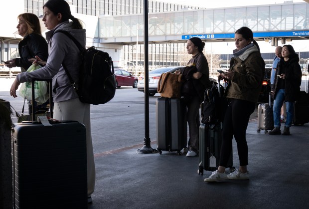 Travelers wait for rideshare pickups at the O'Hare International Airport on Wednesday, Feb. 14, 2024. (E. Jason Wambsgans/Chicago Tribune)