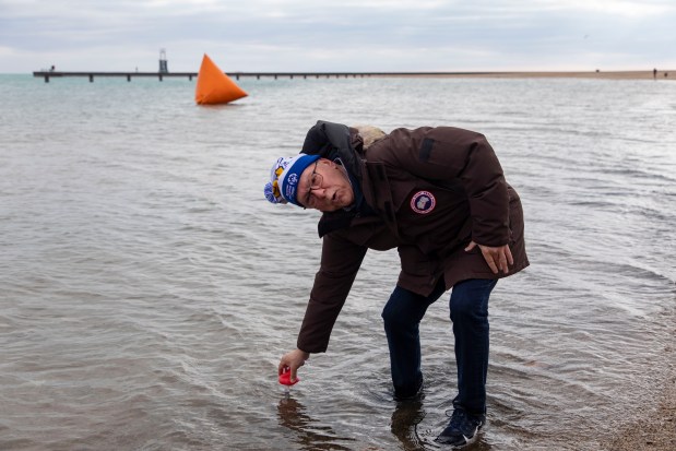 Meteorologist Tom Skilling checks the water temperature before participants jump into Lake Michigan on March 6, 2022, during the 22nd annual Chicago Polar Plunge at North Avenue Beach. (Brian Cassella/Chicago Tribune)