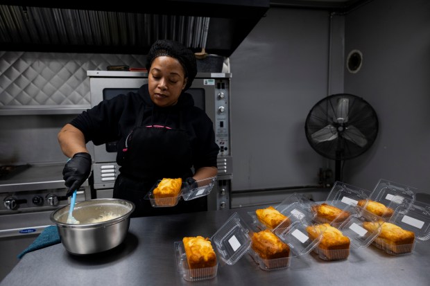 Dedra Simmons, chef and owner of Pookie Crack Cakes, prepares the pineapple paradise cake. (Vincent Alban/Chicago Tribune)