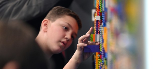 Alexs Djurdjevic, 11, a fifth-grader of Hoffman Estates, moves LEGO bricks on a graffiti art wall at Brick Fest Live on Feb. 17, 2024 at the Lake County Fairgrounds and Event Center. Karie Angell Luc for the Lake County News-Sun.