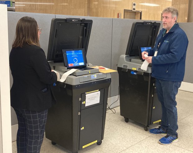 Election workers prepare the machines that will receive ballots on the first day of early voting in Lake County. (Steve Sadin/Lake County News-Sun)