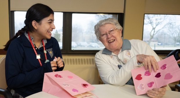 Mother McAuley junior Julissa Gonzalez and Mercy Circle resident Betty Jean Bischel share a laugh as they decorate candy bags to be donated to Pat's Pantry. (Mercy Circle)