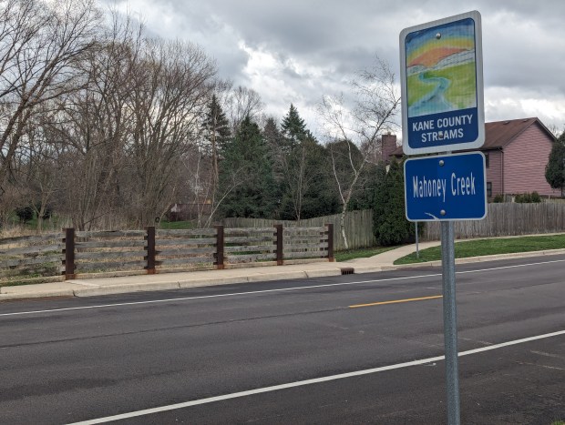 A sign for Mahoney Creek stands in Batavia, where the waterway runs through the city's east side. City officials are warning residents to stay away from the creek after a chemical foam spill earlier in the week. (R. Christian Smith / The Beacon-News)