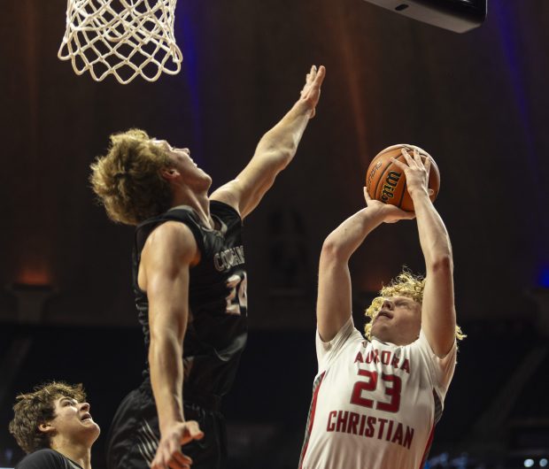 Aurora Christian's Asa Johnson (23) puts up a bank shot as West Central's Chance Little (24) attempts to block it during the Class 1A state semifinals at the State Farm Center in Champaign Thursday, March 7, 2024. (Vincent D. Johnson/for the Beacon-News)