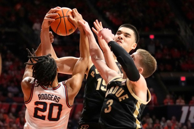 Illinois' Ty Rodgers (20) Purdue's Zach Edey, center, and Braden Smith vie for a rebound during the first half of an NCAA college basketball game Tuesday, March 5, 2024, in Champaign, Ill. (AP Photo/Charles Rex Arbogast)