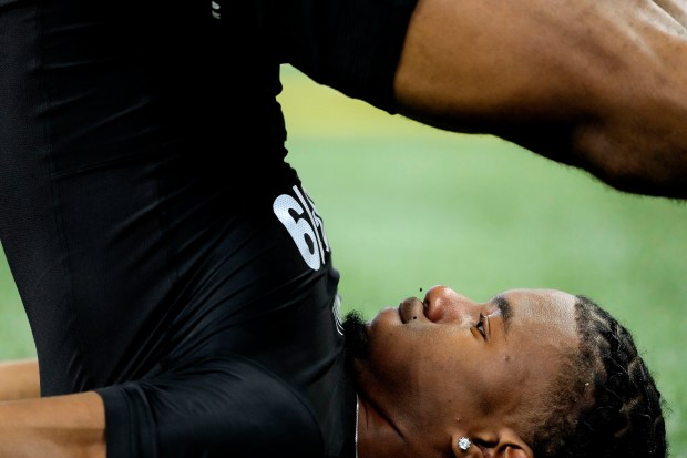 Texas wide receiver Adonai Mitchell participates in a flexibility drill during the NFL scouting combine on March 2, 2024, in Indianapolis. (AP Photo/Charlie Riedel)