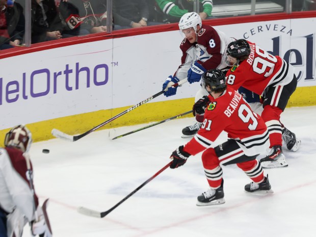 Blackhawks center Connor Bedard (98) reaches for the puck as Avalanche defenseman Cale Makar (8) passes in the first period at the United Center on Feb. 29, 2024, in Chicago. (John J. Kim/Chicago Tribune)