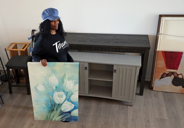 New resident LaTanya McMahan retrieves her favorite art as she moves into Homes of Ashcroft, a new Build-to-Rent community in Oswego, March 16, 2024. (H. Rick Bamman / For the Chicago Tribune)