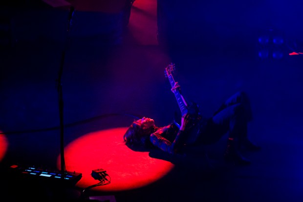 Carrie Brownstein, of Sleater-Kinney, plays guitar while lying down on March 21, 2024, at the Riviera Theatre in Chicago. (Vincent Alban/Chicago Tribune)