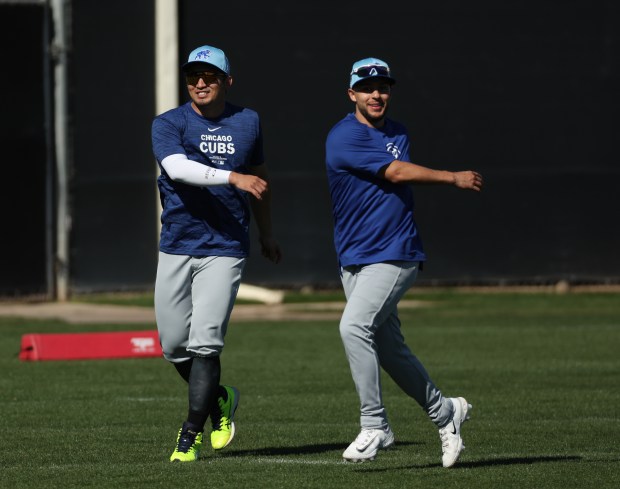 Cubs outfielder Seiya Suzuki, left, and infielder Nick Madrigal warm up during practice on Feb. 22, 2024, at Sloan Park in Mesa, Arizona. (Stacey Wescott/Chicago Tribune)