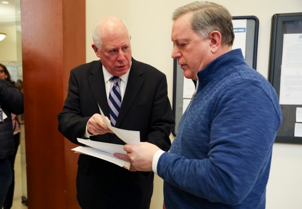 Former Gov. Pat Quinn, left, turns in a proposal on March 27, 2024, to Peter Polacek, managing editor council journal for Office Of City Clerk, for a Chicago ordinance calling for a November voter referendum question on whether any state or local taxpayer money should be spent to build a new stadium for the Chicago Bears or White Sox. (Eileen T. Meslar/Chicago Tribune)