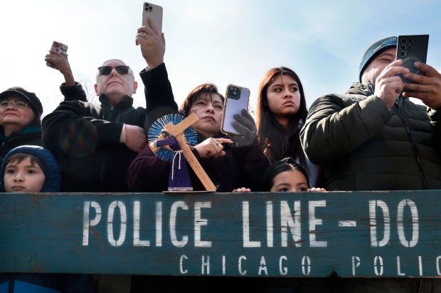 People watch as Jesus is put on a cross during the Good Friday Via Crucis procession in Chicago's Pilsen neighborhood on March 29, 2024. (Antonio Perez/Chicago Tribune)