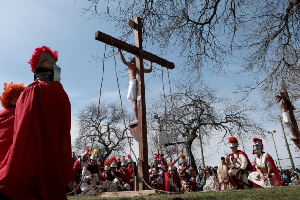 Jesus, played by Tony Diaz, stands on a cross during the Good Friday Via Crucis procession in Chicago's Pilsen neighborhood on March 29, 2024. (Antonio Perez/Chicago Tribune)