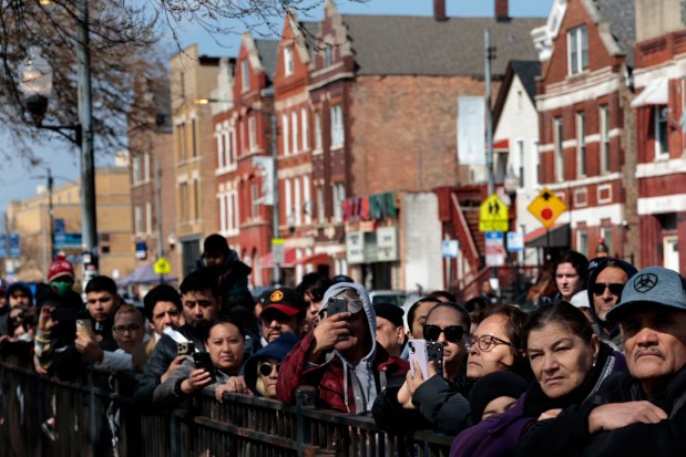 People watch as Jesus, played by Tony Diaz, stands on a cross during the Good Friday Via Crucis procession in Chicago's Pilsen neighborhood on March 29, 2024. (Antonio Perez/Chicago Tribune)