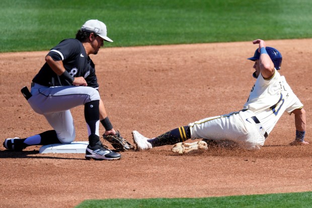 Milwaukee Brewers' Sal Frelick is caught stealing by Chicago White Sox's Nicky Lopez (8) during the first inning of a spring training baseball game, Wednesday, March 13, 2024, in Phoenix. (AP Photo/Matt York)