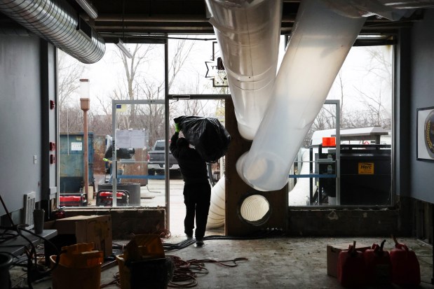 Workers clean up damage at Windy City Curling Club on March 8, 2024, in Villa Park. (Stacey Wescott/Chicago Tribune)