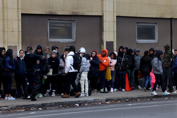 Dozens of migrants line up outside the State of Illinois Department of Human Services building at North and California avenues in Chicago on March 28, 2024, in hopes of receiving assistance or documents. (Antonio Perez/Chicago Tribune)