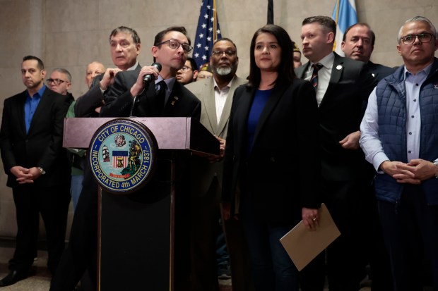 Ald. Raymond Lopez, at mic, stands with Ald. Silvana Tabares as they and others condemn the actions of Ald. Byron Sigcho-Lopez at City Hall on March 27, 2024. Ald. Sigcho-Lopez spoke last week at a rally in front of a burnt American flag. (Antonio Perez/Chicago Tribune)