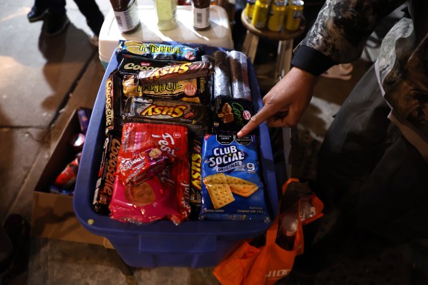 Venezuelan migrant Rengi Jesus Faltime sells candy and soda near the Salt Shed concert venue on Feb. 29, 2024. (Chris Sweda/Chicago Tribune)