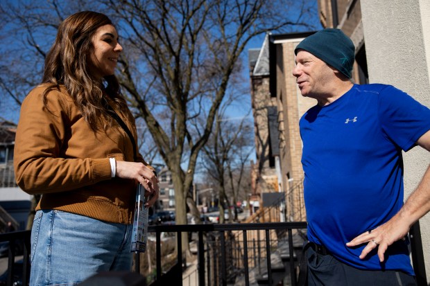 State Sen. Natalie Toro, D-20th District, left, speaks with Howard Simon, right, outside his home while canvassing for her reelection throughout the Bucktown neighborhood on Dec. 30, 2023, in Chicago. (Vincent Alban/Chicago Tribune)