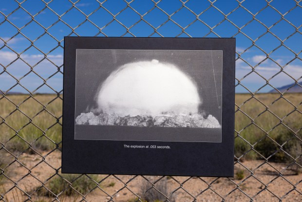 A historic image of the first nuclear bomb test is posted on a fence at the Trinity Test site at White Sands Missile Range in New Mexico in Oct. 2022. (John Burcham/The New York Times)