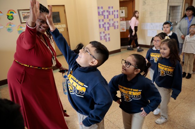 Kindergarten teacher Yaquala Grant gives high-fives to her students as they celebrate the announcement that St. Francis of Rome Catholic Elementary School in Cicero will not be closing on March 6, 2024. (Antonio Perez/Chicago Tribune)