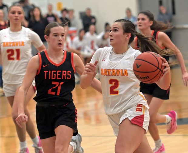 Batavia's Brooke Carlson drives to the basket past Wheaton Warrenville South's Ashlyn Adams. Batavia defeated Wheaton Warrenville South 55-36, in the Class 4A Bartlett Regional final girls basketball game Friday, February 16, 2024, in Bartlett, Illinois. (Jon Langham/photo for the Beacon-News)