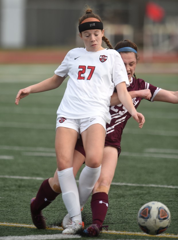 Lincoln-Way Central's Lila Hadley (27) gets taken down by Lockport's Kaylin Klutcharch (25) Tuesday, April 4, 2023 in Lockport, IL. (Steve Johnston / Daily Southtown)