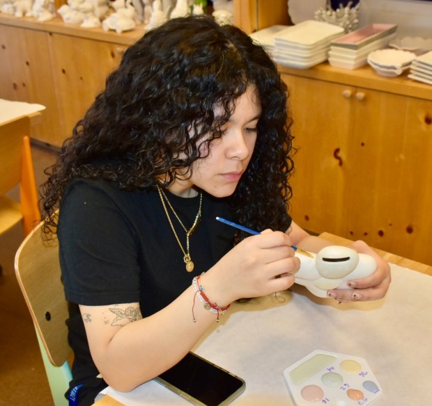 Yariceo Escobedo, 22, of Aurora, tries out her artistic skills at Color Me Mine, a paint-your-own-pottery studio in Naperville. (Steve Metsch/Naperville Sun)
