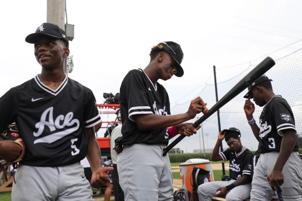 Demir Heidelberg, center, of the White Sox ACE 14U team gets his bat ready before a game against New York's DREAM team at the Field of Dreams site in Dyersville, Iowa on Aug. 11, 2021.