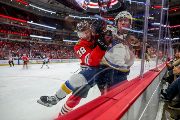 Blackhawks defenseman Ethan Del Mastro, left, pushes Blues center Dylan McLaughlin into the glass during a preseason game on Sept. 27, 2022, at the United Center. (Armando L. Sanchez/Chicago Tribune)